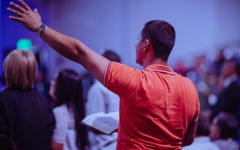 man raising his left hand